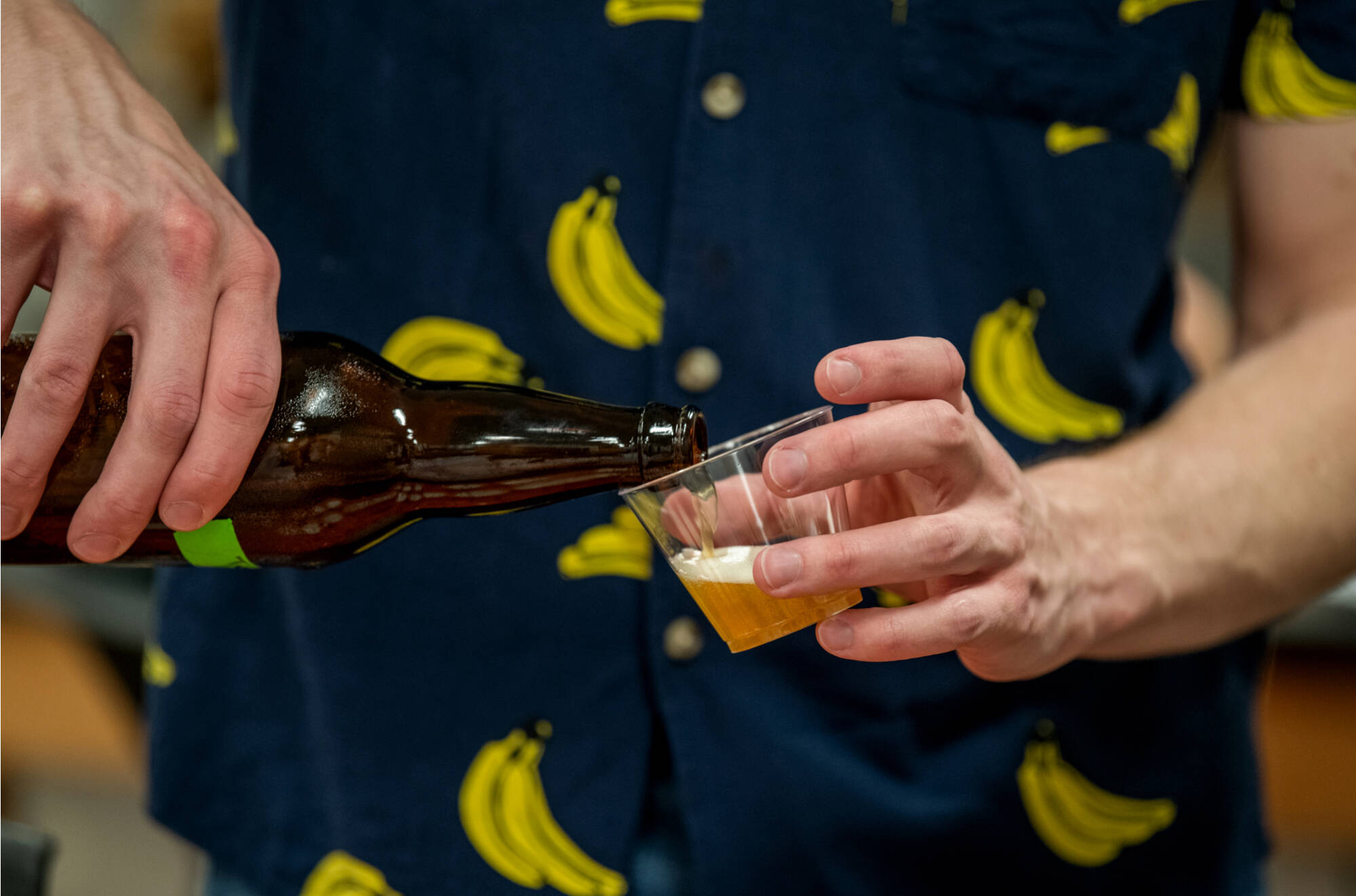 Student pouring beer brewed in class.
